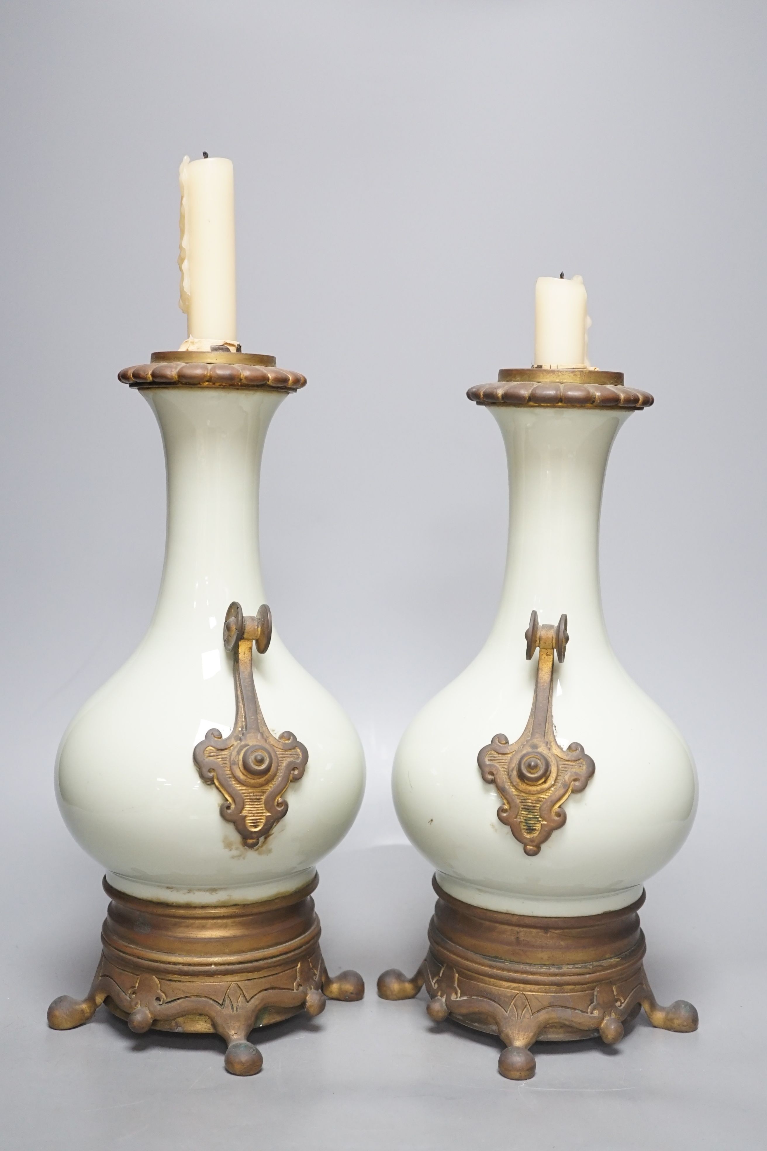 A pair of French celadon ground vases, now used as candlestands, total height 30cm